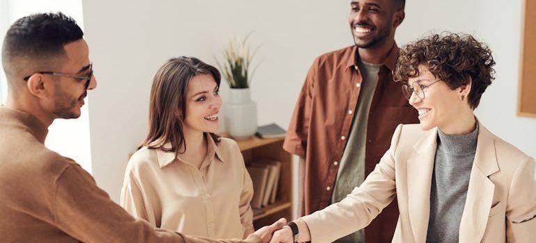 People in the office talking and shaking hands.